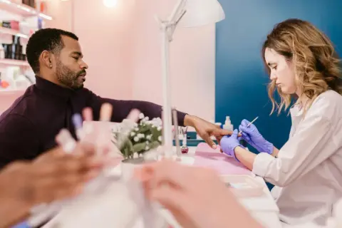 Mann lässt sich im Nagelstudio die Nägel machen. Ein Kleingewerbe wie dieses unterliegt der IHK-Pflicht.