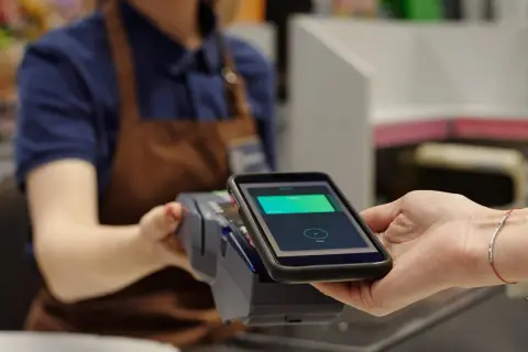 Bezahlvorgang mit Smartphone: Eine virtuelle Kreditkarte wird an einem Terminal abgerechnet.