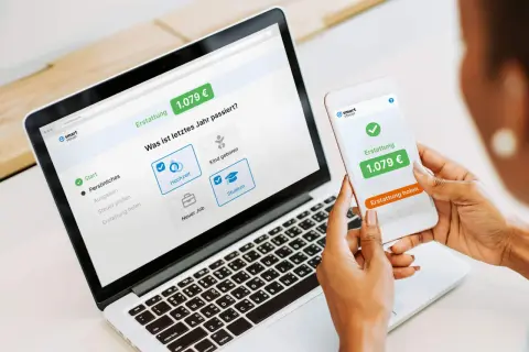 Eine Person nutzt smartsteuer auf Laptop und Smartphone. Die gute smartsteuer erfahrung zeigt eine Erstattung von 1.079 €.