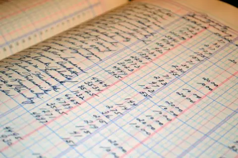 Alte Buchhaltungsseiten mit handschriftlichen Einträgen und Zahlen. Hier wird gezeigt, wie man Buchhaltung selber machen kann.